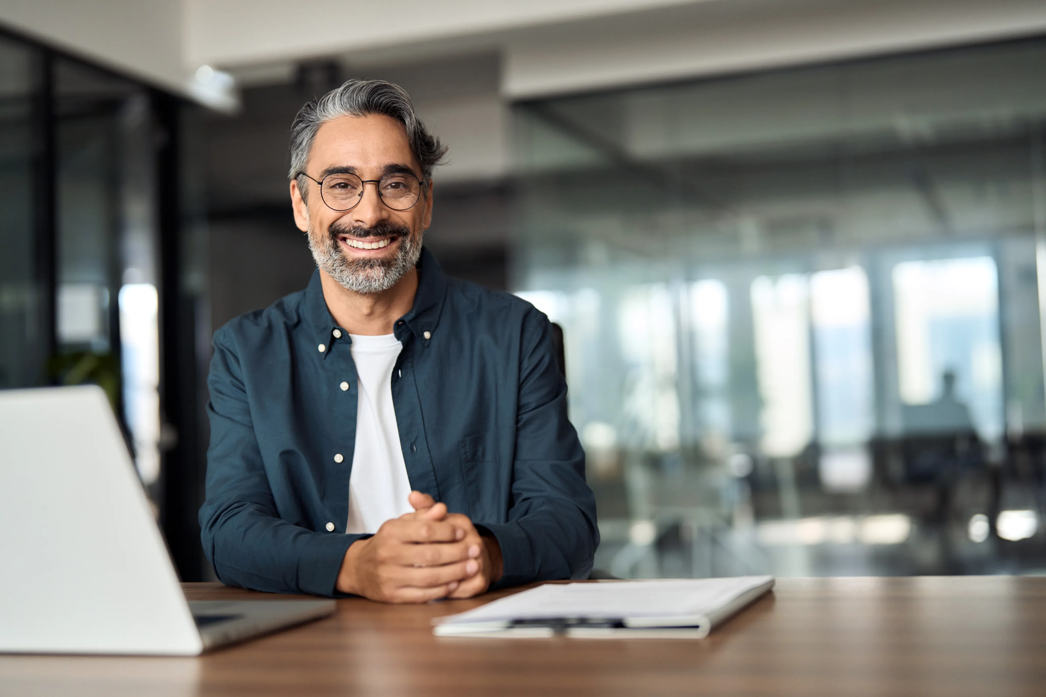 A business owner smiling at his desk